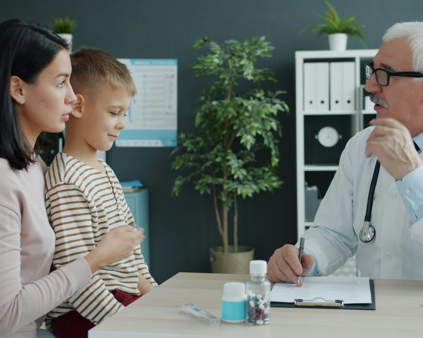 A doctor speaking warmly with a parent and child at Klinik Ceria