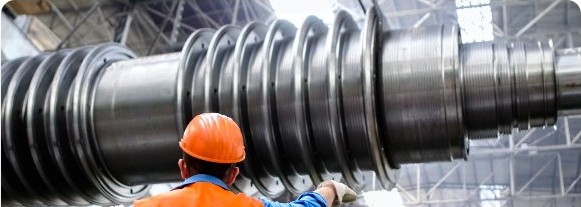 Engineer in safety helmet and high-visibility vest inspecting industrial machinery
