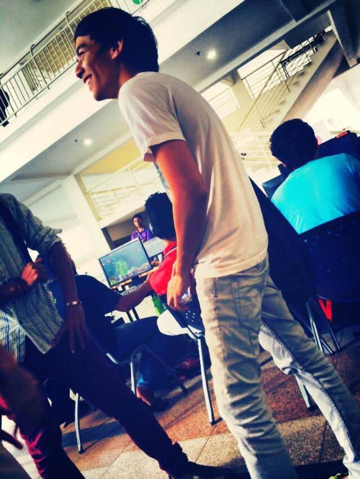 Ajak, founder of Ajak.Web, laughing mid-conversation in a bright indoor space, wearing a white t-shirt